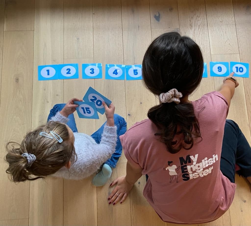 An assistant playing a number card game with a child
